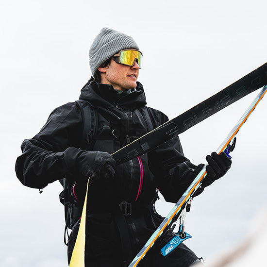Man attaching touring skins to skis wearing the SMITH Pursuit Sunglasses
